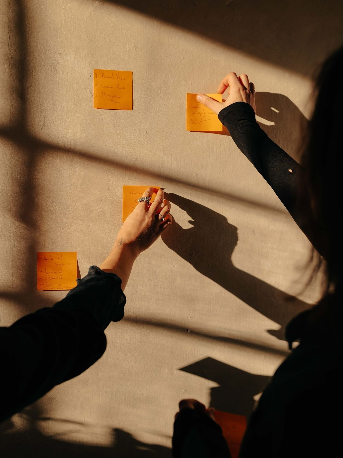 A hand ticking off items on a to-do list beside a coffee cup